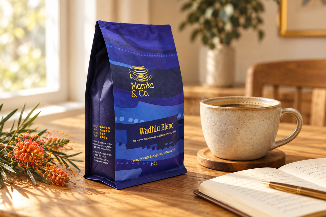 Marnka & Co. Wadhlu Blend bag beside a cup of coffee and an open notebook with grevillea